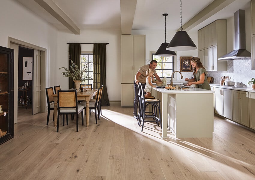 A family stands around a kitchen island talking