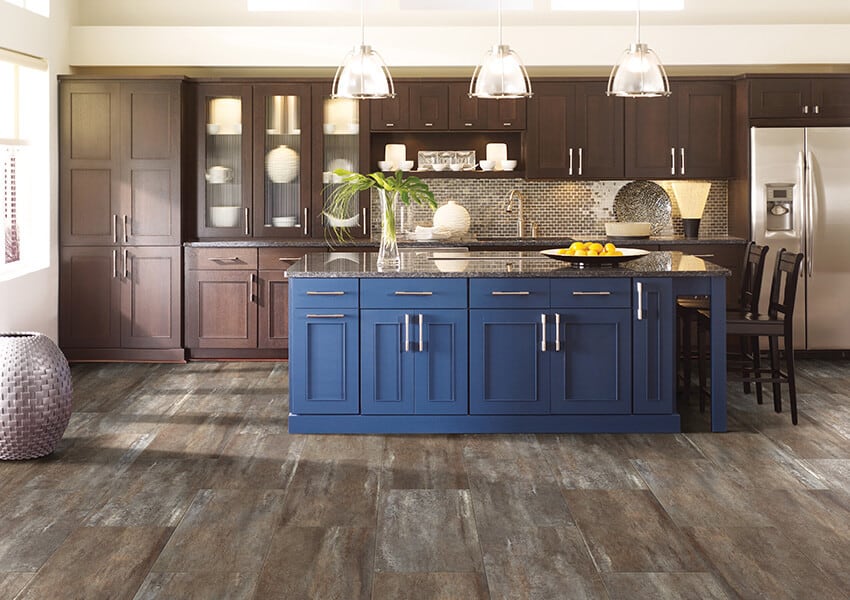 A blue kitchen island seen on beautiful luxury vinyl flooring