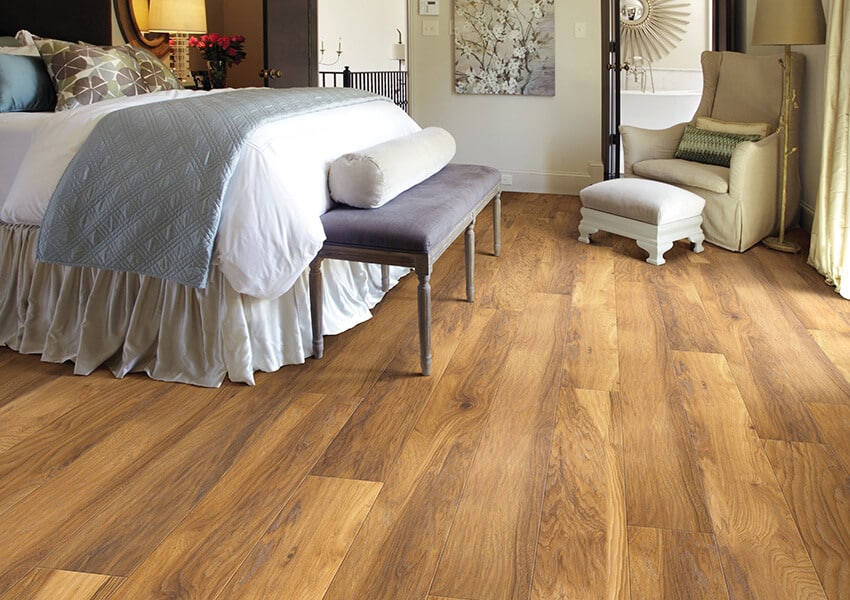 Two-tone brown laminate flooring in a bedroom