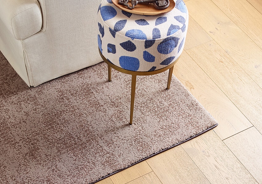 A square area rug on a hardwood floor